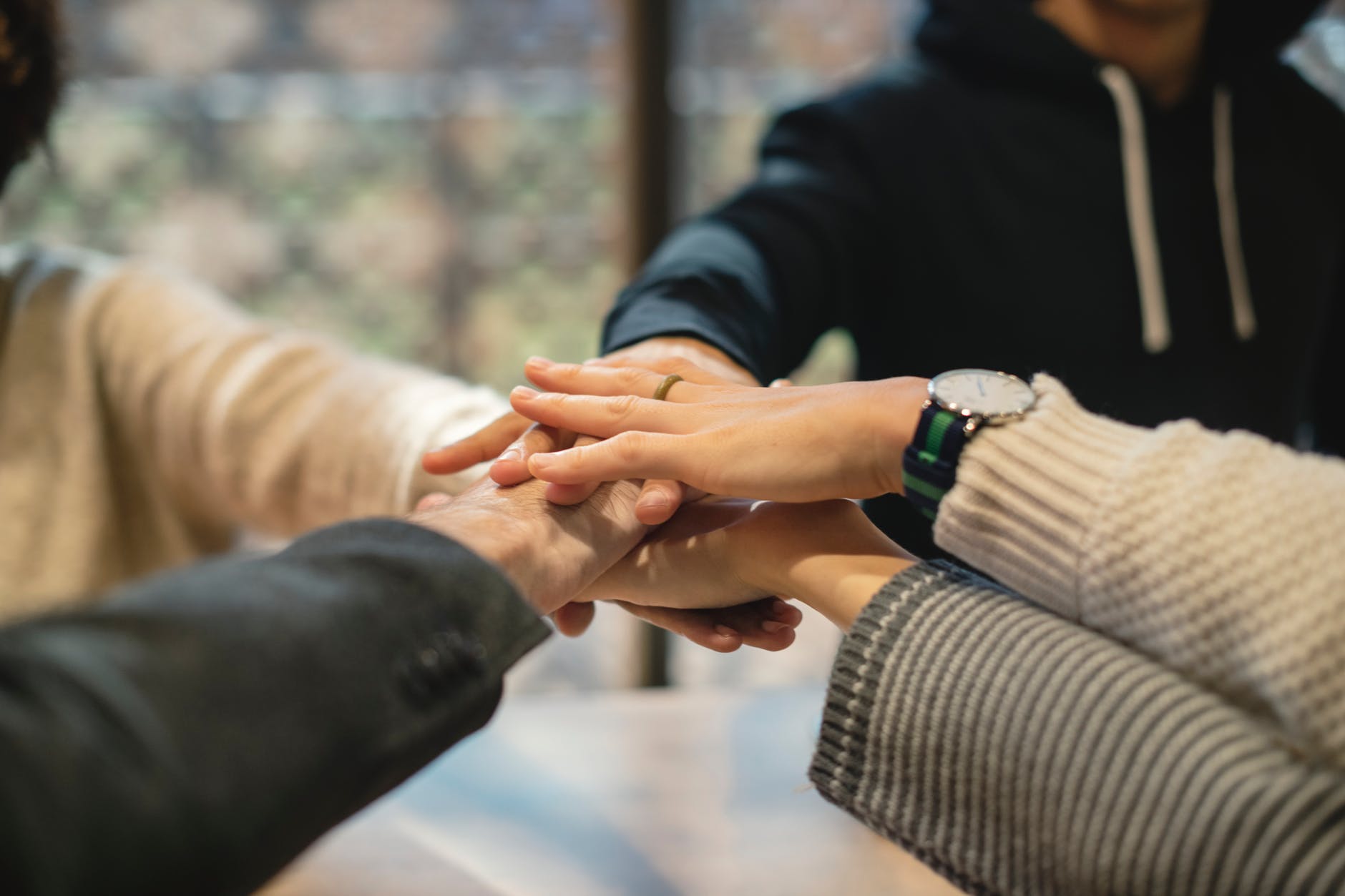 shallow focus photography of five people holding each other hands